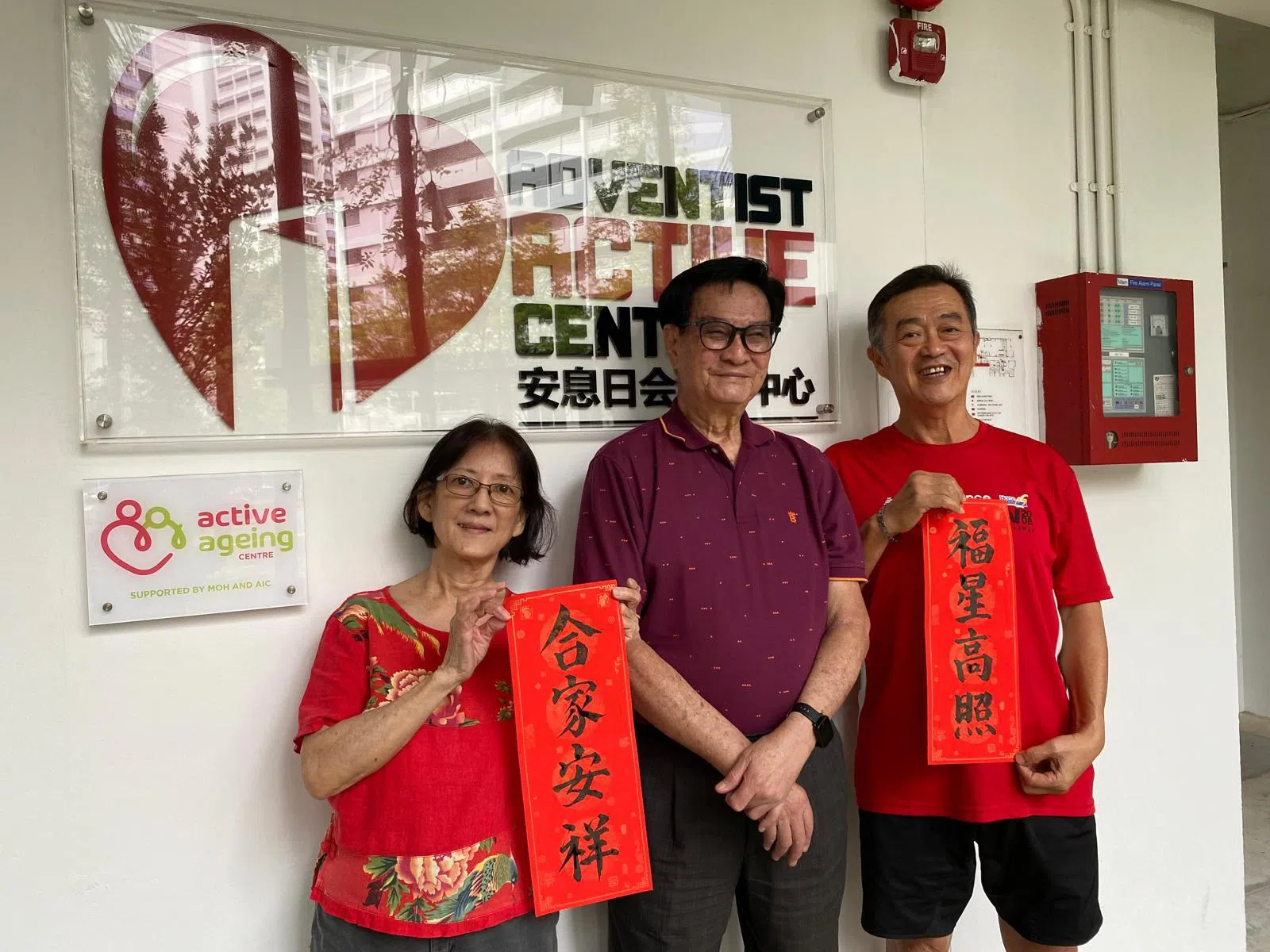 谭永青（中）是安息日会活跃中心的兼职员工，多年来教导无数乐龄人士书法，在农历新年期间常将春联赠送访客和老人。图为谭永青与Golden Peony安息日会活跃中心书法班学生合照。（安息日会活跃中心提供）