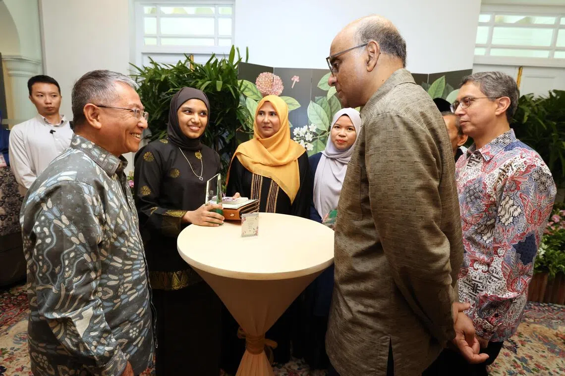 新加坡回教理事会星期六在总统府举行颁奖礼，活动主宾尚达曼总统（右二）在主管回教事务代部长费绍尔副教授（右一）的陪同下，与获颁卓越服务奖的家暴庇护所Casa Raudha主席阿都哈米（左一），以及代表父亲、已故杰出社区领袖阿拉丁领取真诚服务奖的纳兹拉（左三）交流。（梁麒麟摄）