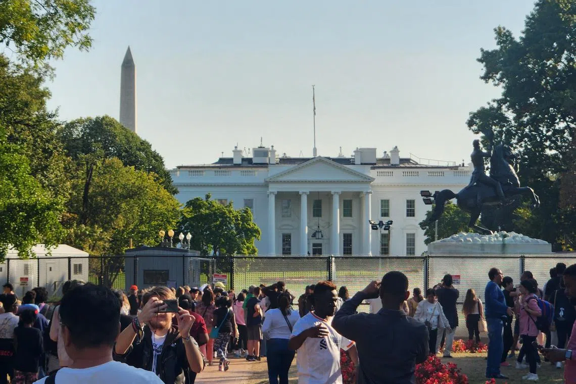 美国选民11月5日将在共和党总统候选人特朗普和民主党总统候选人哈里斯之间选出白宫下一位主人。图为今年10月初，隔着围栏在白宫北草坪外拍照的游客。（蓝云舟摄）