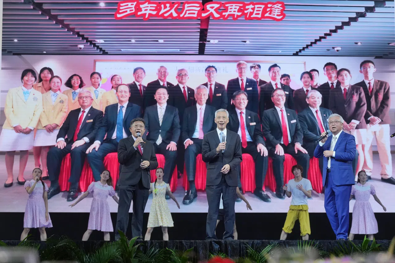 国务资政李显龙（前排中）在晚宴上同宗乡总会会长蔡其生（前排右）、中华总商会会长高泉庆（前排左）一起演唱经典新谣歌曲《细水长流》。（谢智扬摄）