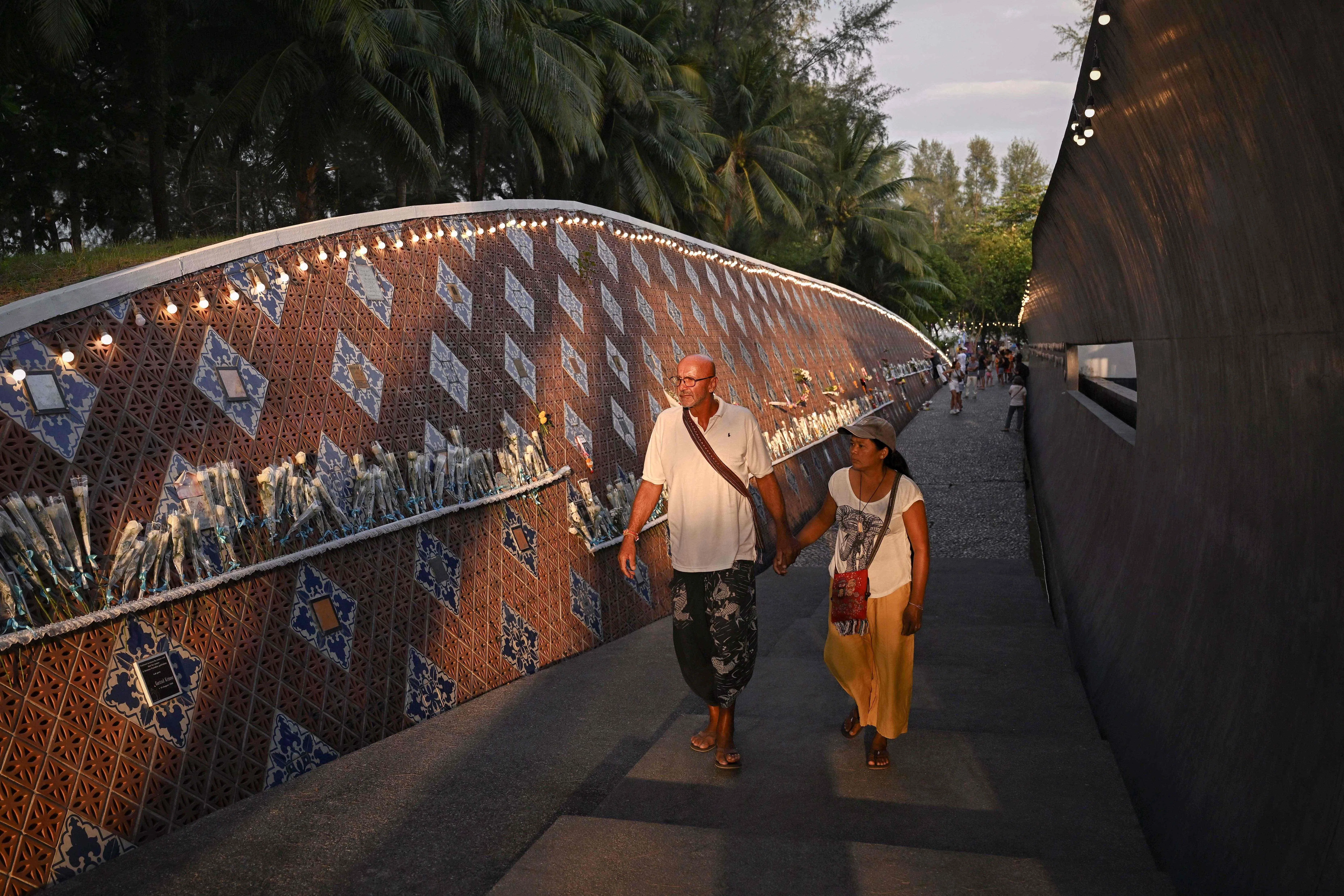 班南肯渔村在印度洋海啸10周年时建起海啸纪念园，墙上挂着刻了1400多个遇难者姓名的牌子。（法新社）