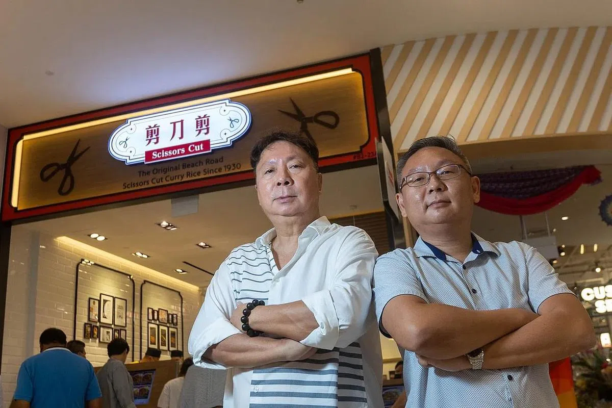 “美芝律剪刀剪咖喱饭”第三代负责人李家伯（左）和第四代负责人吴俊威（右）继承家业，扩大经营。（关俊威摄）