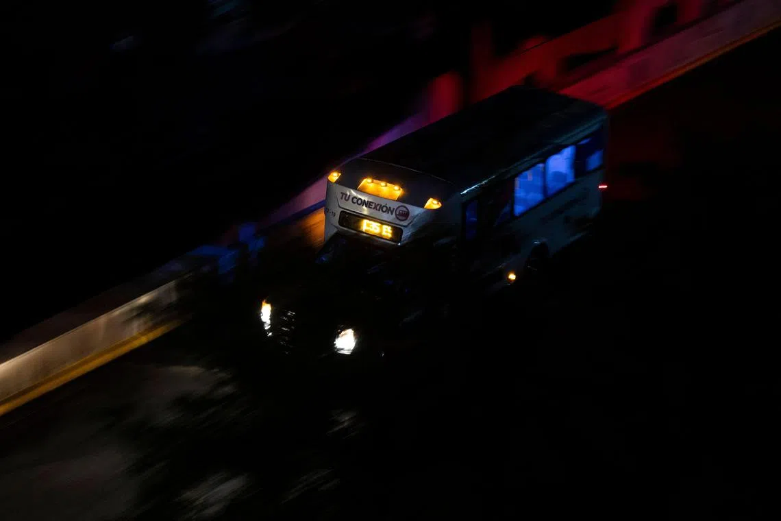 电流中断后，一辆巴士在没有街灯照明的圣胡安道路上前行。（法新社）