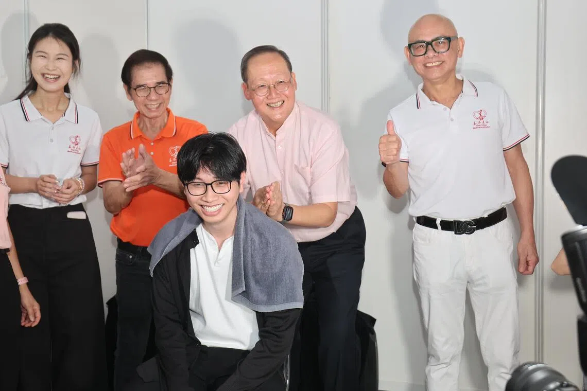 人力部长陈诗龙医生（右二）参观国际客工日庆祝活动的展览摊位，即兴帮客工按摩，善济医社主席卓顺发（右一）在旁陪同。（唐家鸿摄）