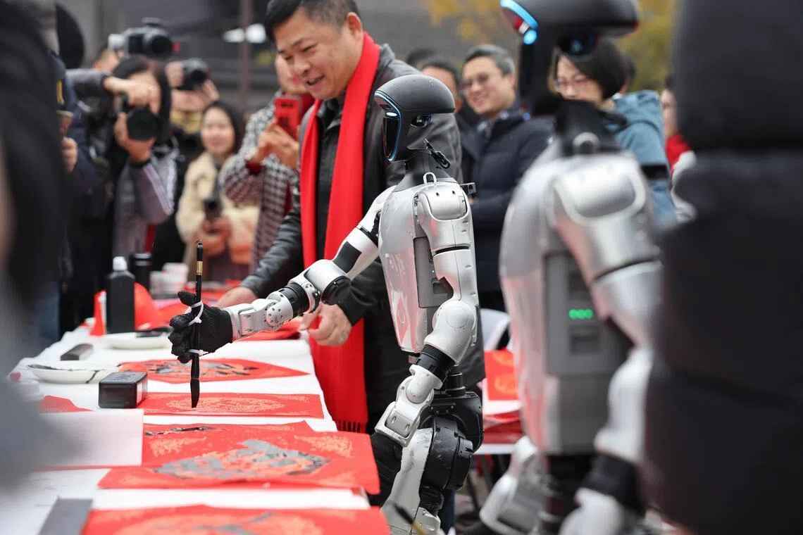 业内人士认为，人形机器人行业目前还需要靠公共叙事和社会关注度来驱动增长。图为2月7日四川成都一场活动中，人形机器人握持毛笔写春联。 （中新社）