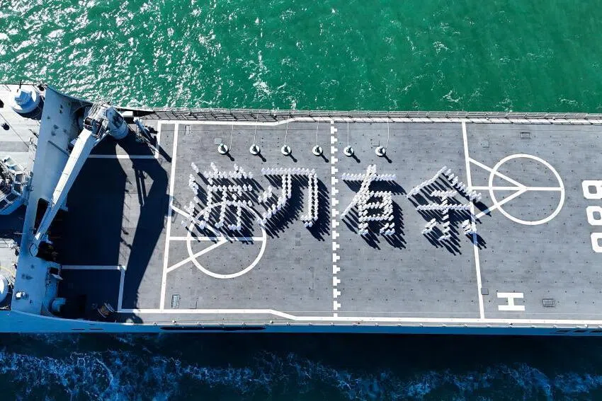 来自中国海军工程大学和海军航空大学的军校学员，在综合登陆舰“长白山舰”的飞行甲板上，摆出“游刃有余”字样。（新华社）