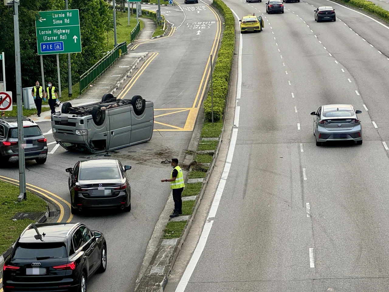 路上轮胎痕迹显示小货车突然撞入路肩，随后翻覆。（邝启聪摄）