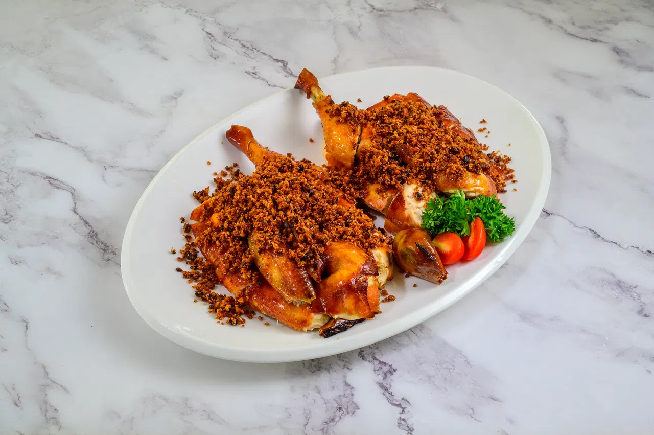 香辣蒜爆金鸡最后加上的滚热香辣蒜米，使鸡皮变得更香脆。（餐馆提供）