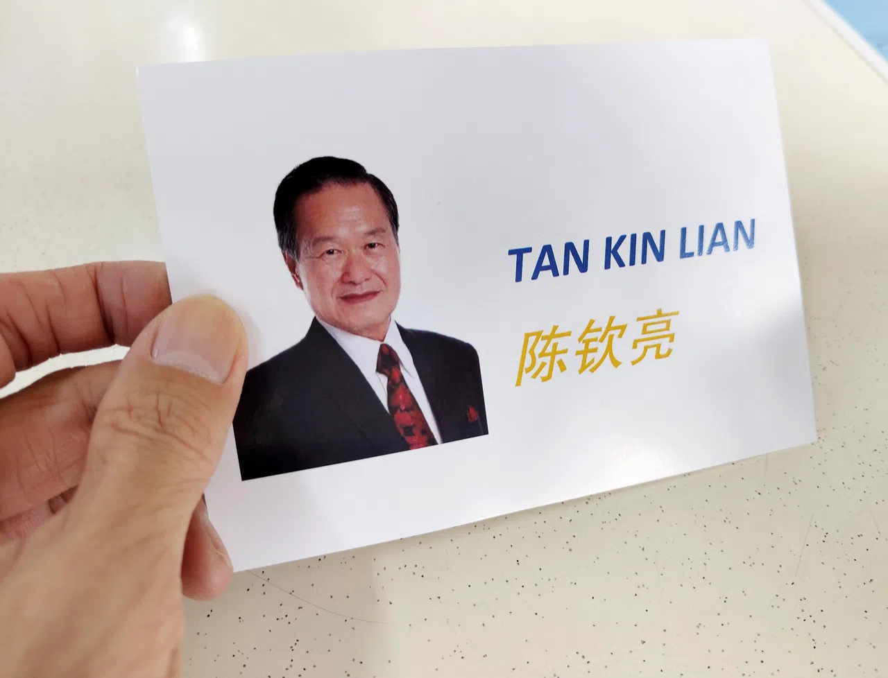 陈钦亮的传单设计简单，只有明信片大小。正面是他的照片和中英文名字，背面是鱼尾狮和市中心的风景。（曾坤顺摄）