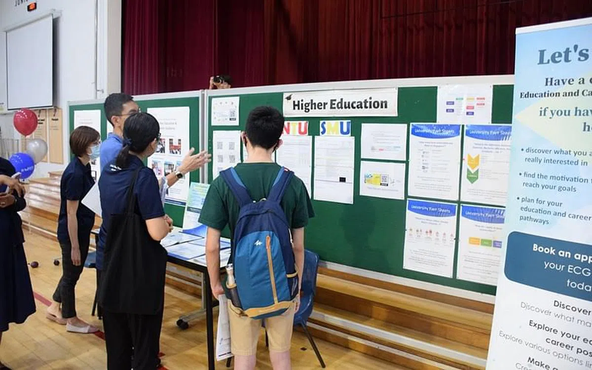 学生与家长在“高等教育”展摊前了解相关资讯。（裕驱记者学会提供）