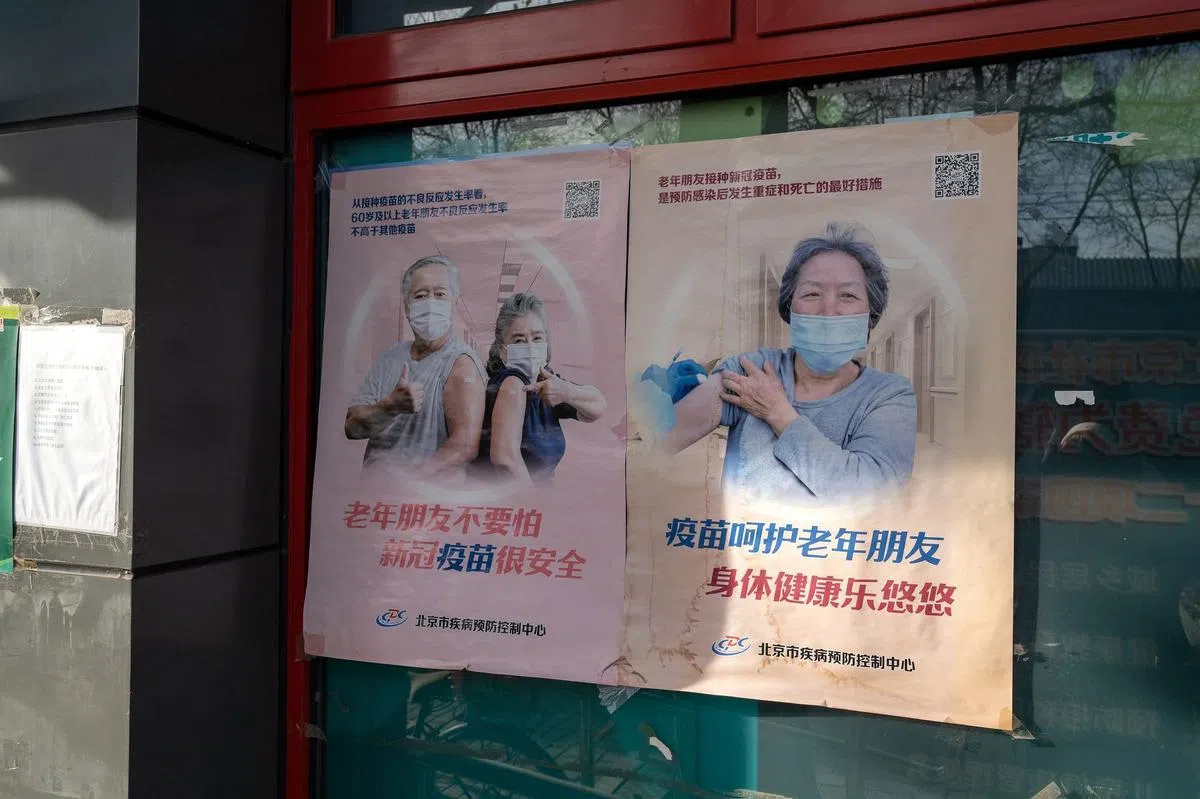 中国官方近日发布通知，提出要加快推进老年人冠病疫苗接种。图为北京街道呼吁老年人接种疫苗的海报。（彭博社）