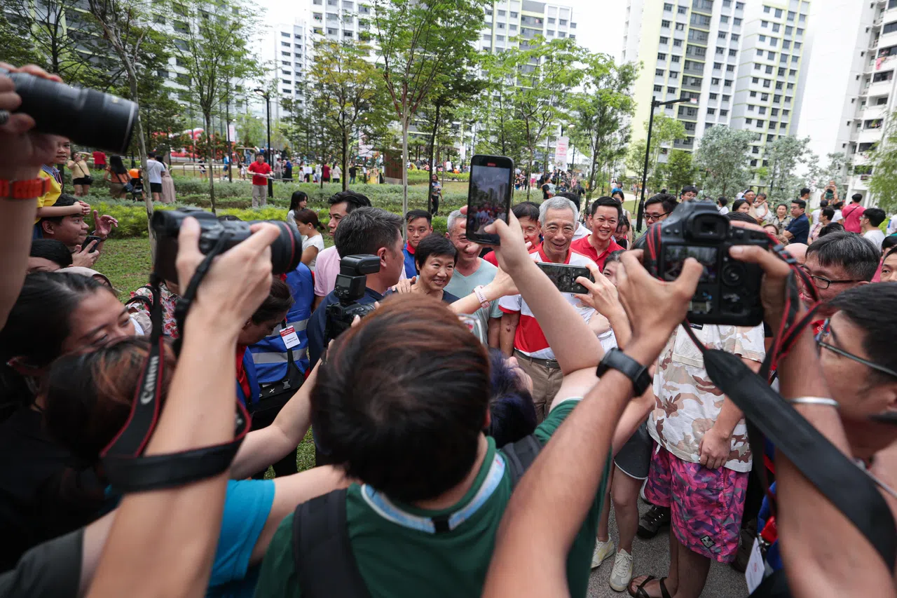 李总理在前往活动现场的路上被公众团团围住，争相与他拍照。总理也以笑脸回应大家的热情，来者不拒。（李冠卫摄）