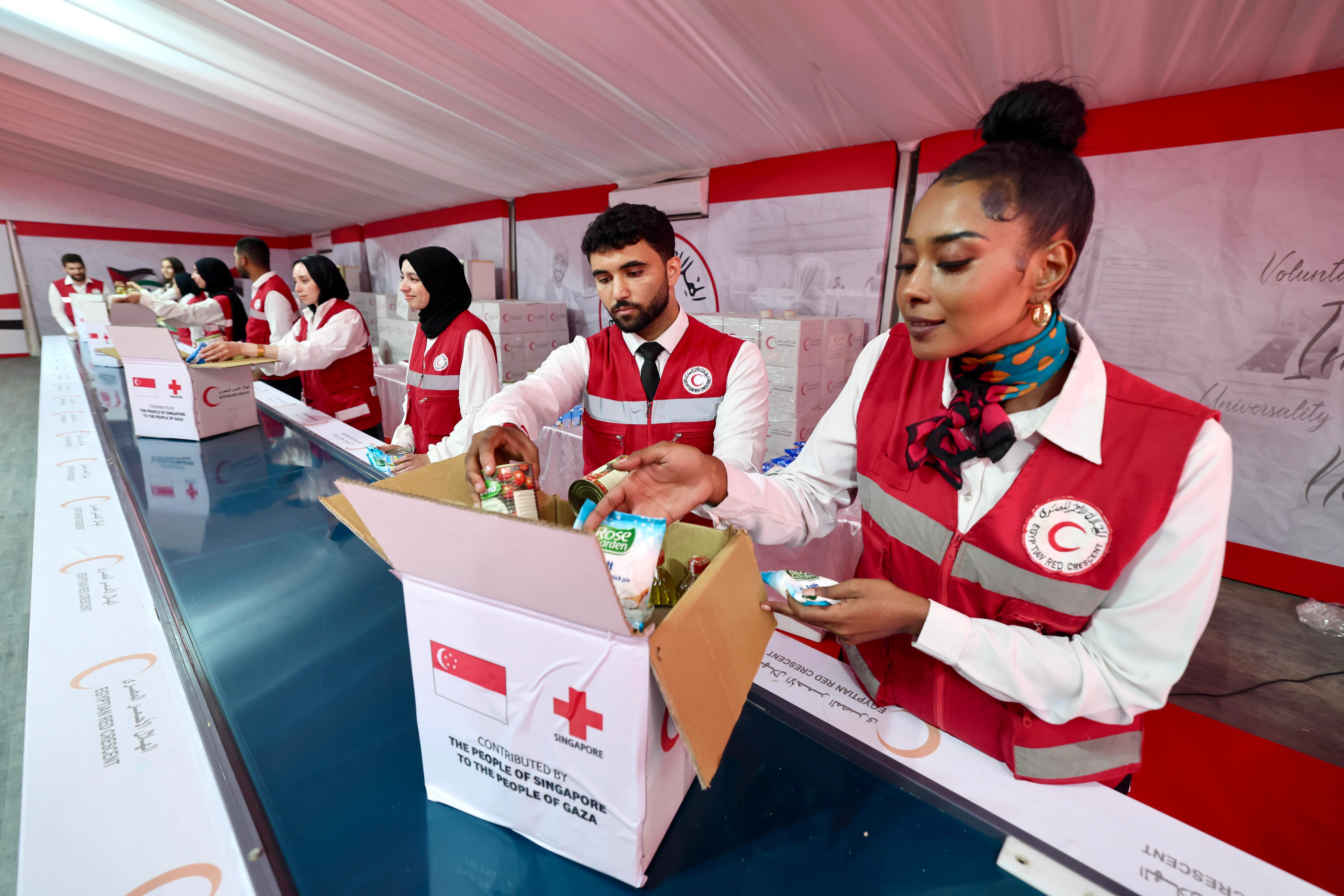 埃及红新月会义工把食品装进箱子，这些物资都将提供给撤离到埃及的巴勒斯坦人。（陈斌勤摄）