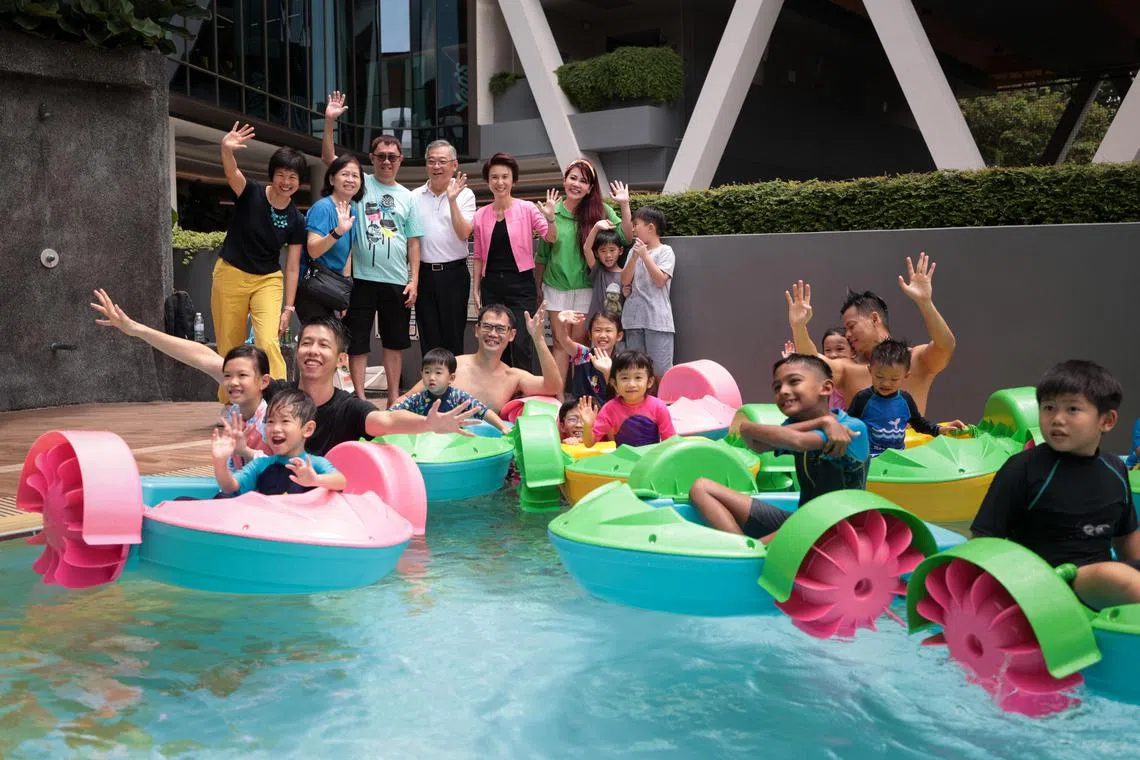 副总理兼贸工部长颜金勇（后排左四）及西南区市长刘燕玲（后排右四）星期天在蔡厝港战备军人协会俱乐部举行的嘉年华会上，为西南幸福家庭计划主持推展仪式。（张俊杰摄）