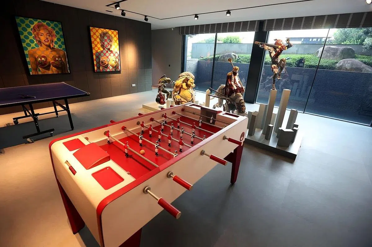 地下室藏有一台爱马仕桌上足球机，墙上则挂有Ron English的玛丽莲梦露画作。（龙国雄摄）