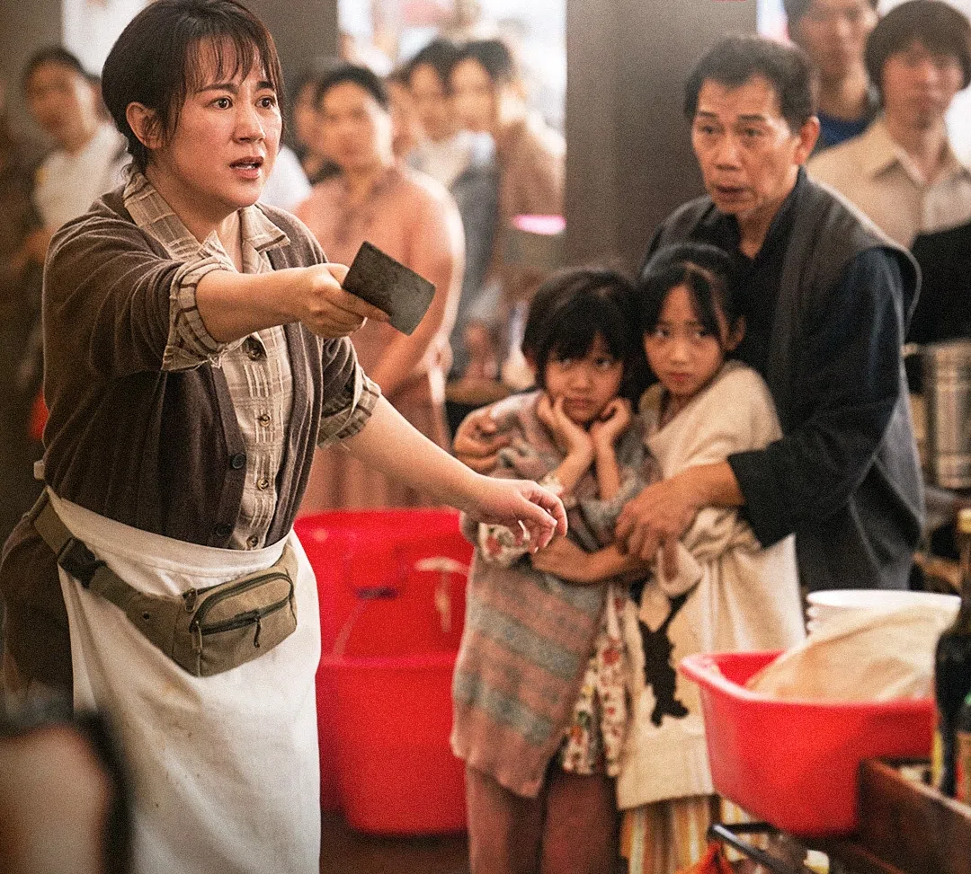 马丽（左一）饰演的臧健和为了保护两个女儿，挥起菜刀阻挡闹事的流氓。（取自《水饺皇后》官方微博）