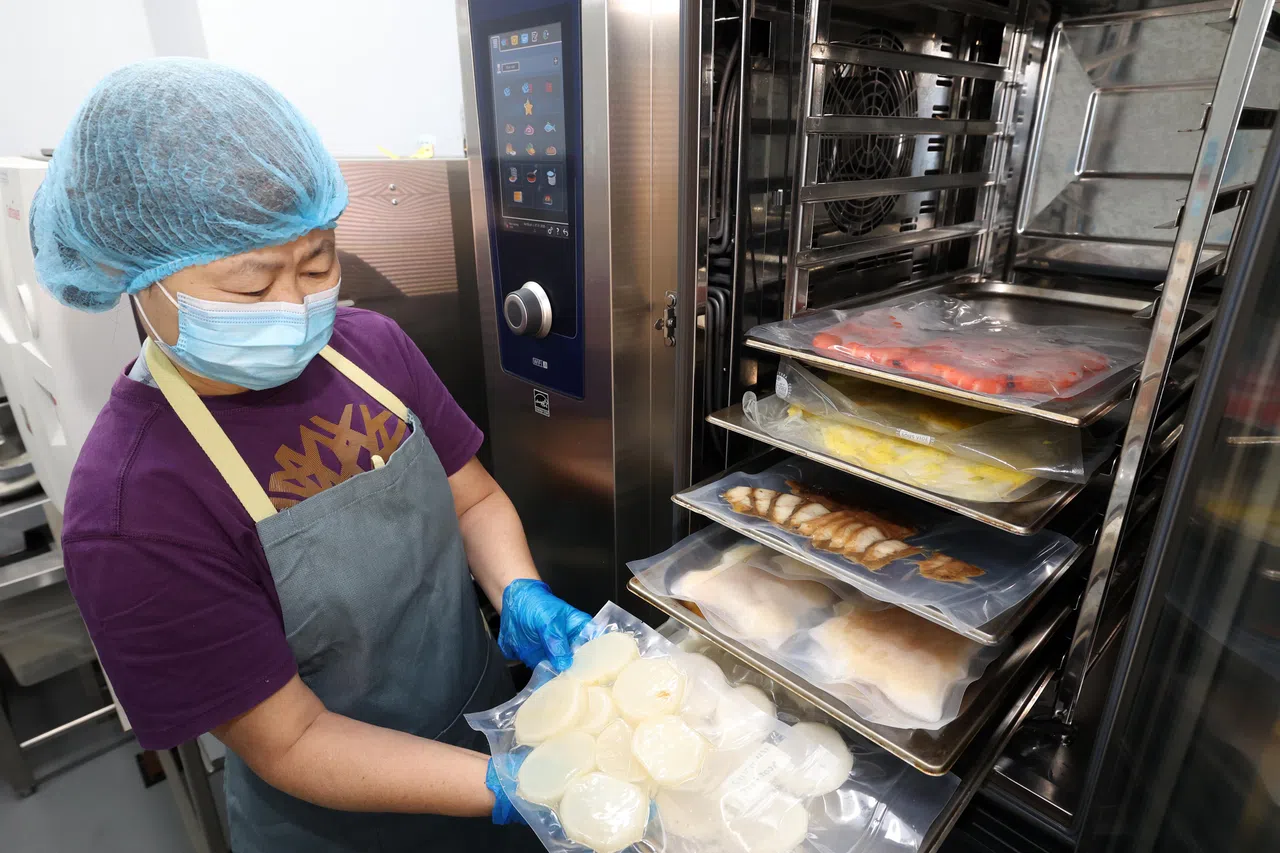 蓝海洋中央厨房主管曾美好向记者介绍，具有AI功能的烤箱每层温度可单独设定，并可隔着食品级真空包装带给盆菜的各种食材同时加热，将营养“锁”在袋中。（邝启聪摄）