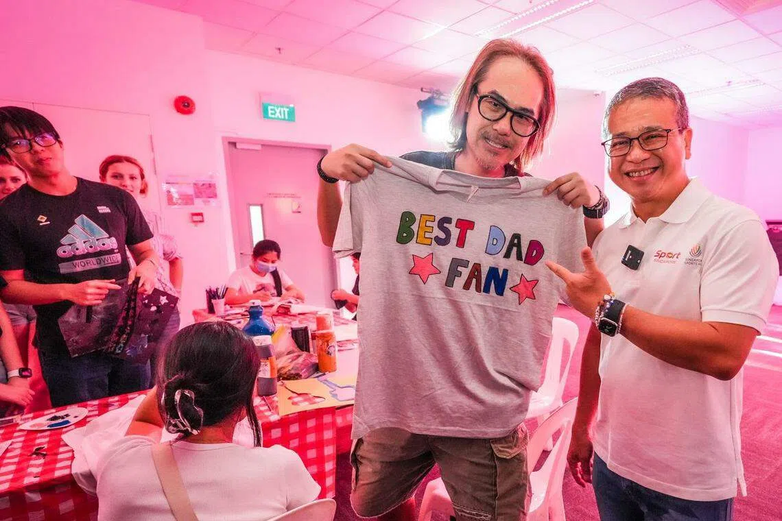 文化、社区及青年部长兼律政部第二部长唐振辉（右）星期六傍晚于泰勒丝首场演唱会场外活动区与一名Swiftie（泰勒丝粉丝）父亲合照。唐振辉说，他的女儿都是泰勒丝铁粉，因此他也是一名Swiftie爸爸。（新加坡体育城提供）