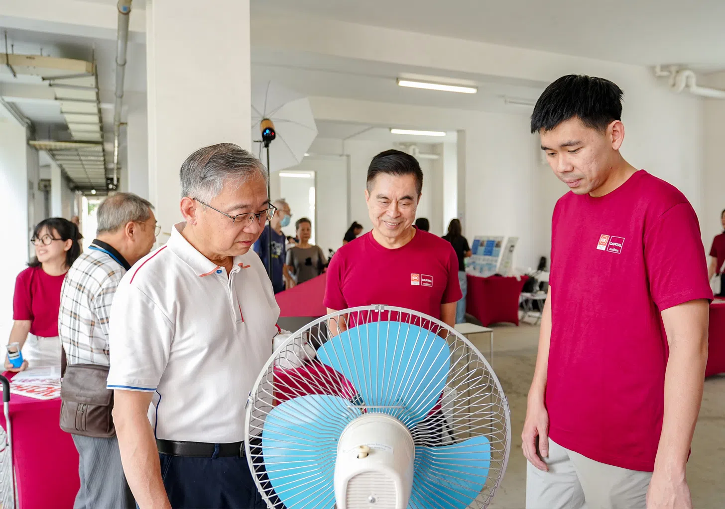 Deputy Prime Minister Gan Kim Yong viewing older KDK fan models and speaking with KDK representatives