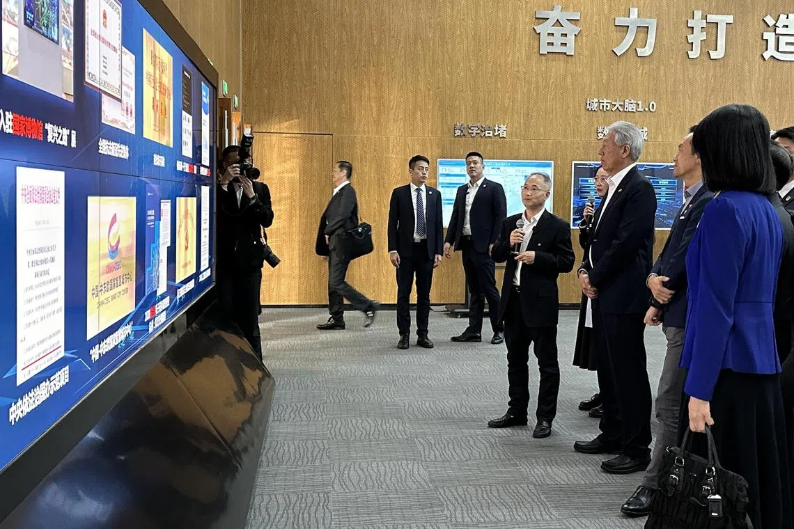 杭州市政府副秘书长、市数据资源管理局长徐青山（右四）向国务资政兼国家安全统筹部长张志贤（右三）介绍杭州城市大脑系统。（陈婧摄）