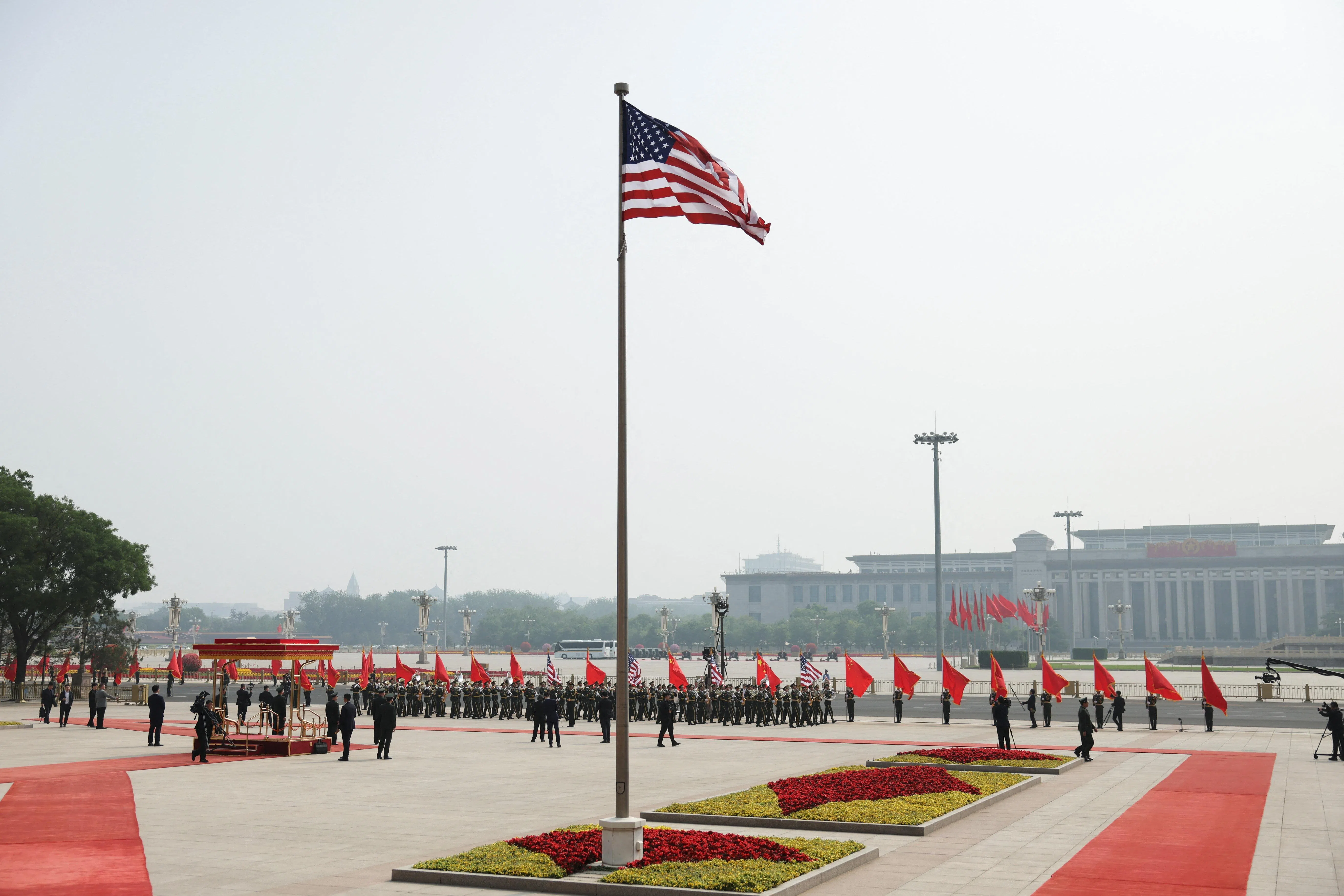 美国国旗星期四（5月14日）在中国北京人民大会堂迎风飘扬，仪仗队在为美国总统特朗普举行的欢迎仪式进行彩排。（路透社）