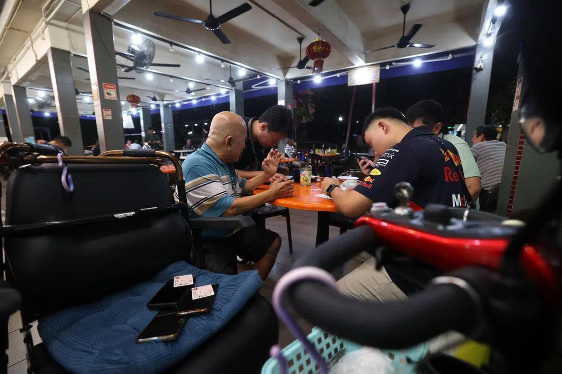 警方将嫌犯的手机和证件收走，放在其中一名嫌犯的轮椅上。（陈斌勤摄）