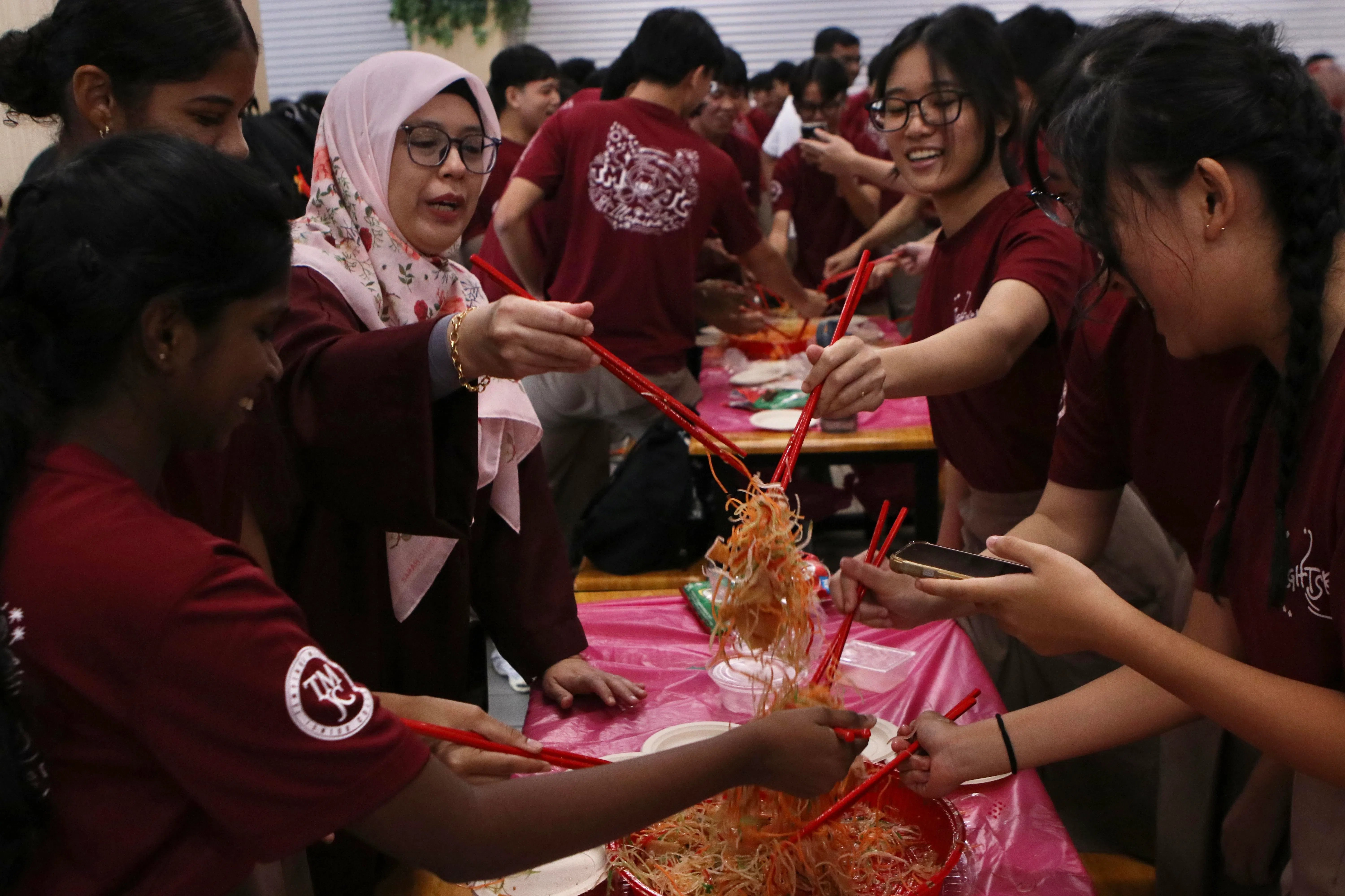 淡美初院师生济济一堂齐捞鱼生。（淡美初院摄影俱乐部提供）