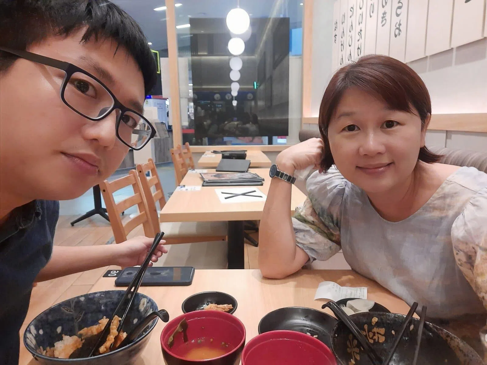 纪广雄（左）觉得病情好转时会停药，导致病情反反复复，无法工作。图为他与母亲庄月清一起用餐。（受访者提供）