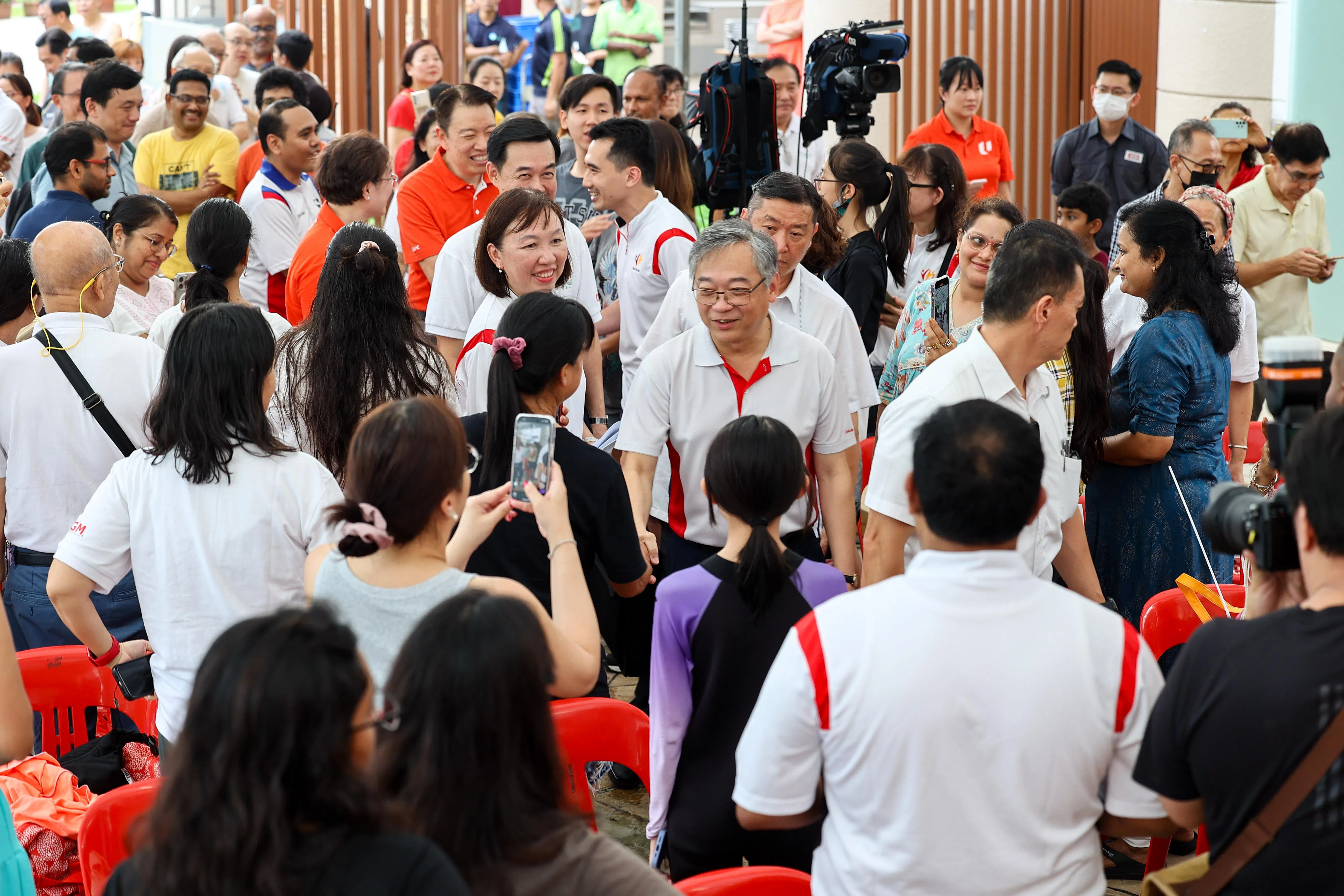 副总理兼贸工部部长颜金勇（着红白制服并戴眼镜者），参加北桦园公寓居民日活动。（陈渊庄摄）