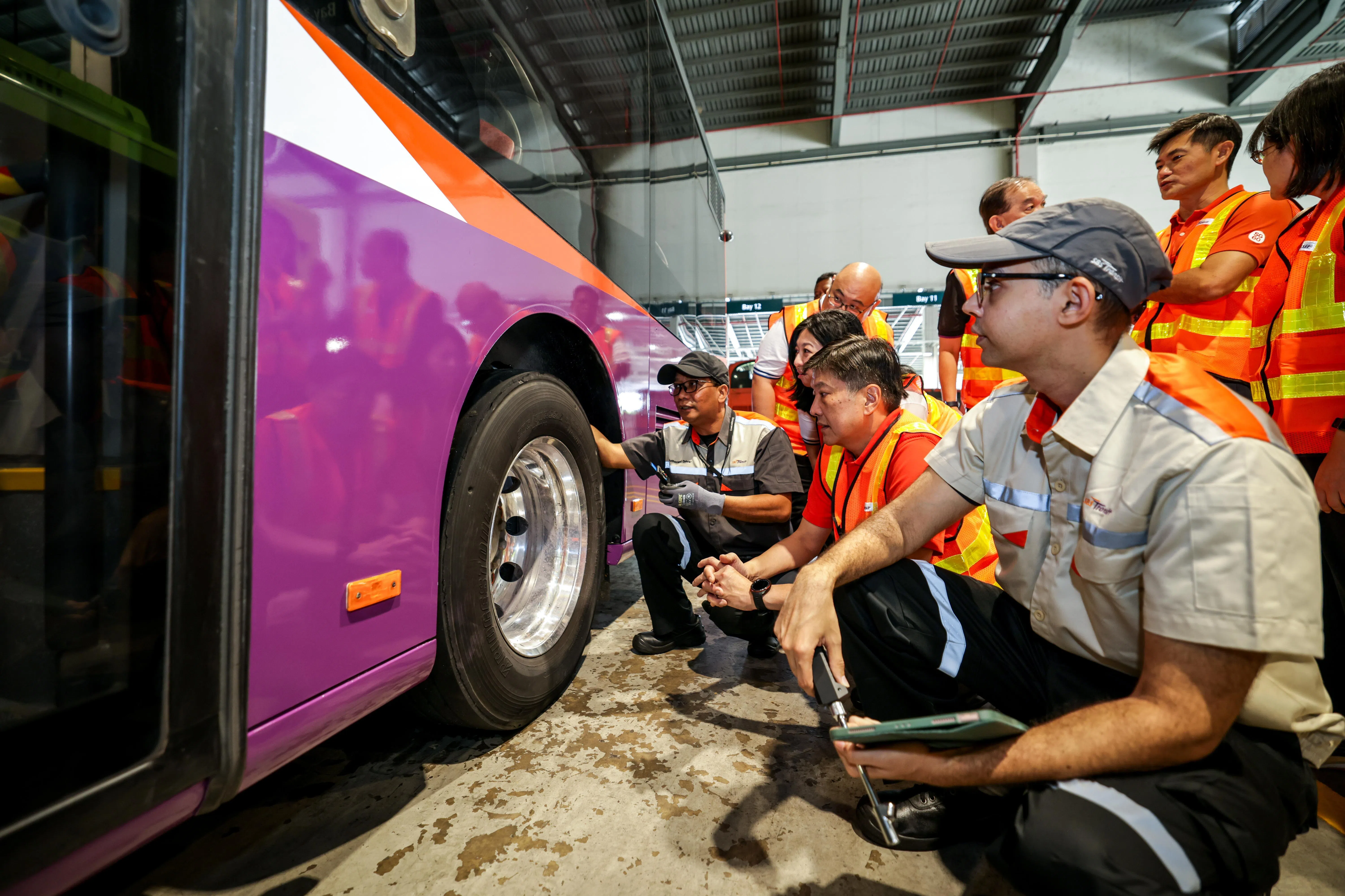 全国职工总会秘书长黄志明（前排右二）与职总副秘书长陈国明（后排右二）和助理秘书长杨涴淩（前排右三）在新捷运的实里达车厂，与维修诊断专员交流，并了解新捷运的自动轮胎管理系统。（叶振忠摄）