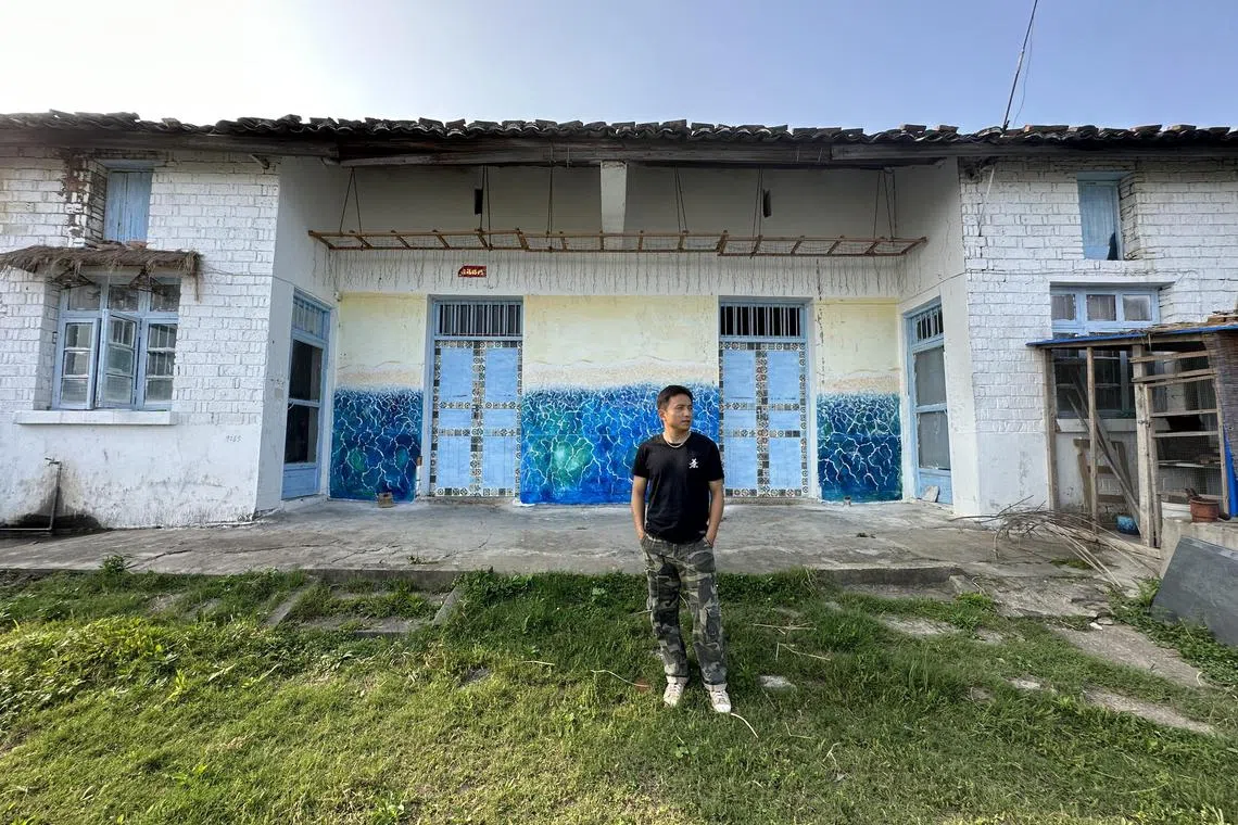 41岁的画家范文强是这家私人青年养老院的主理人，他在养老院的外墙上画了一幅海浪图，营造海边别墅的感觉。（林煇智摄）