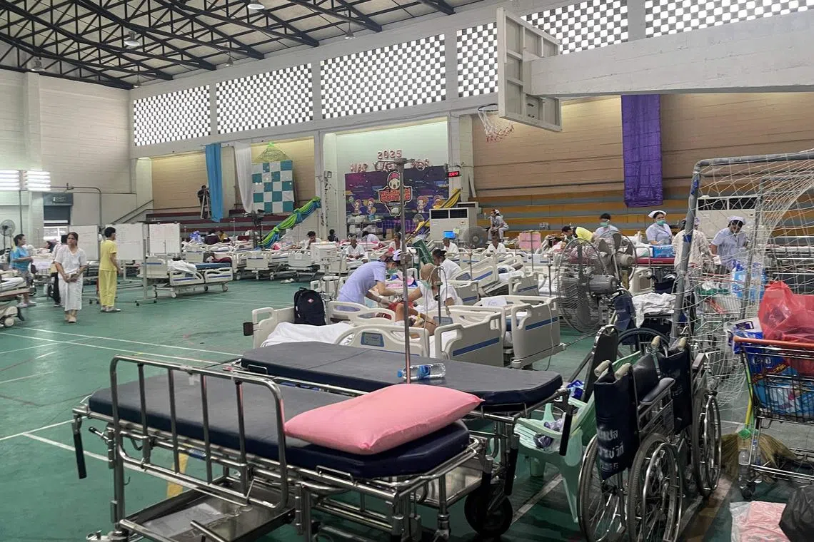 曼谷一家医院因担心医院建筑受损，将病人转移到一个体育场馆，在此提供输血等基础医疗服务。（法新社）