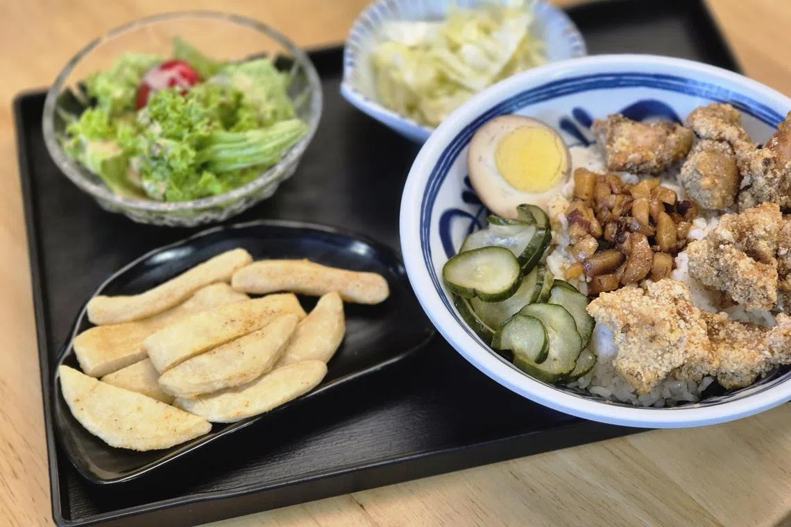 盐酥鸡饭套餐，加上甜不辣小吃、沙拉和炒青菜。（陈爱薇摄）