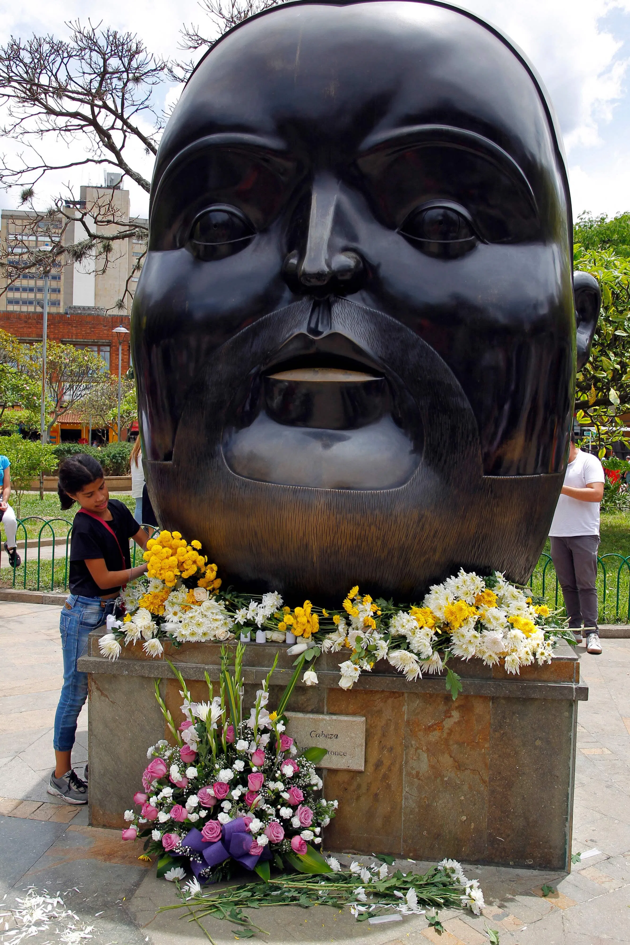 一个女孩到哥伦比亚麦德林的博特罗广场鲜花哀悼艺术家的逝世。 （法新社）