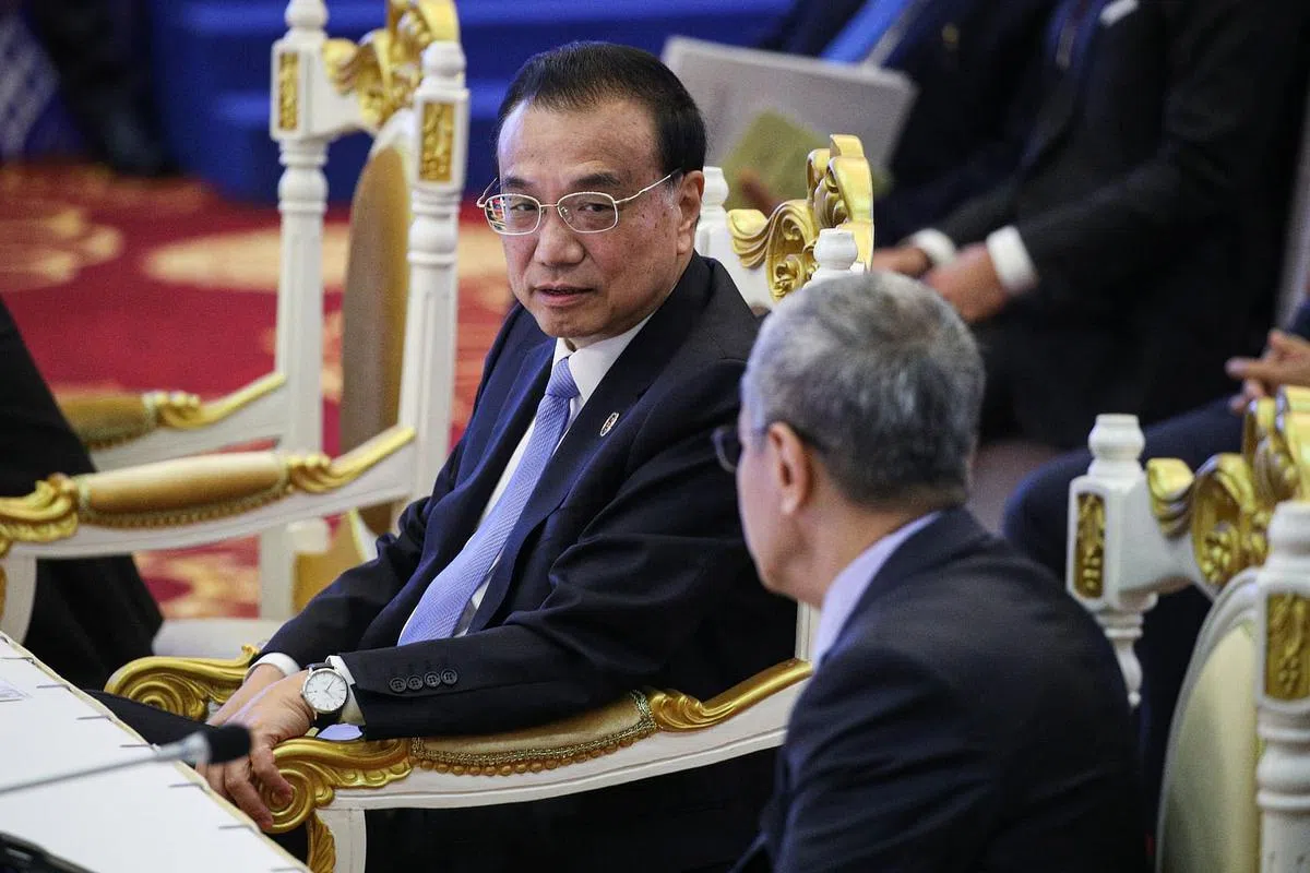 中国总理李克强（左）星期天在柬埔寨金边出席东亚峰会时，跟以特使身份出席峰会的马来西亚前国会下议院议长阿兹哈交流。（李健玮摄）