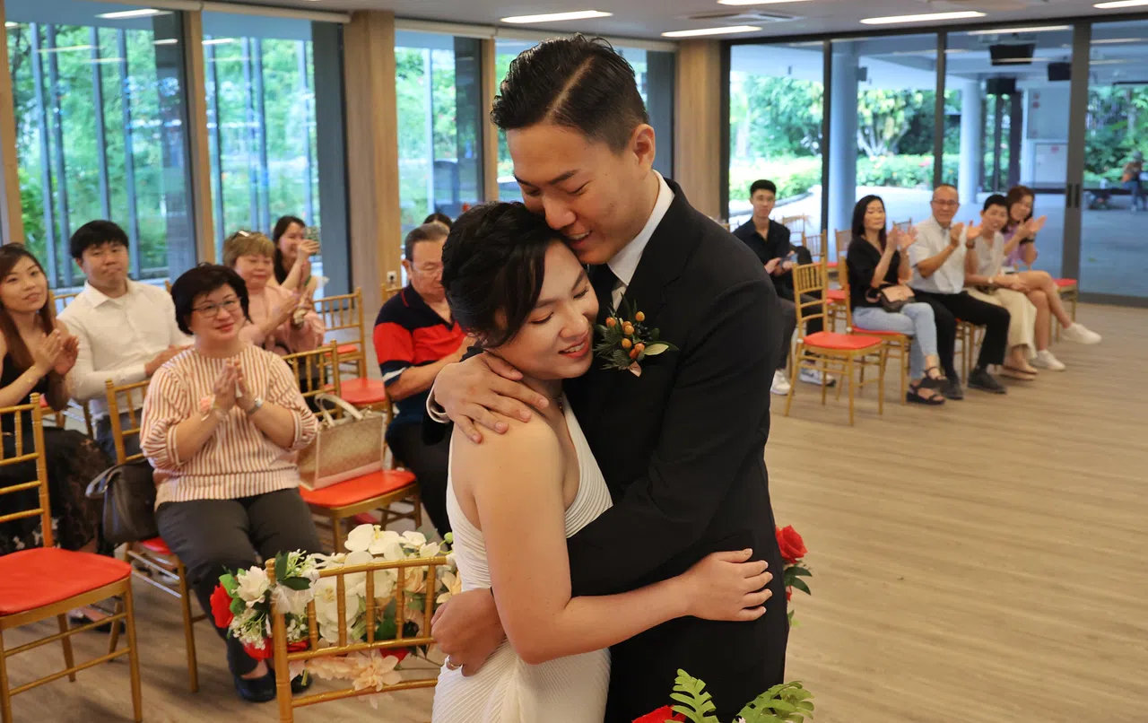 朱政諹（右）与黄洁欢（左）在亲友们的见证下相拥，在罕有的闰日决定注册结婚。（唐家鸿摄）