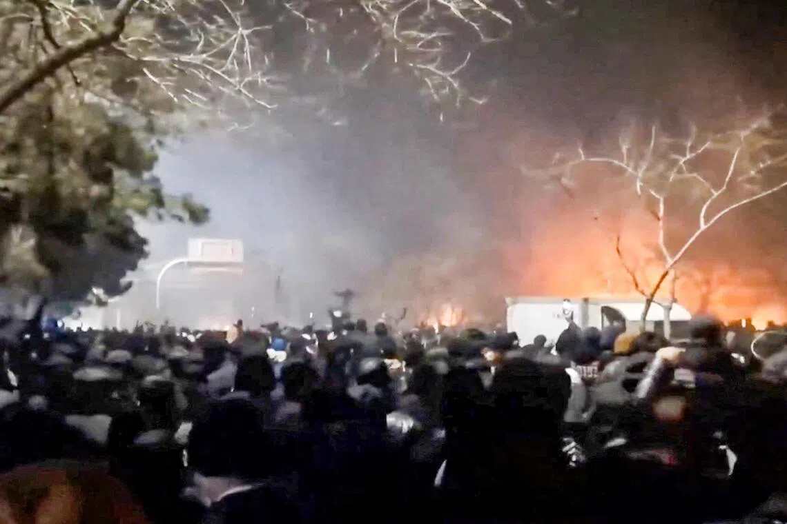 社交媒体上的一段视频显示，伊朗反政府示威者周六晚聚集在霍拉桑省马什哈德市（Mashhad）一条高速公路上，现场可见火光与浓烟。（路透社）