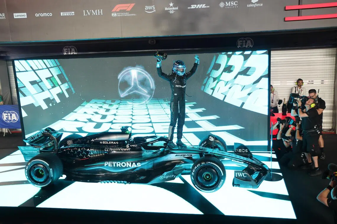 马赛地车手拉塞尔（中）在夺冠后将马赛地赛车驶上属于冠军的停车坪。（唐家鸿摄）