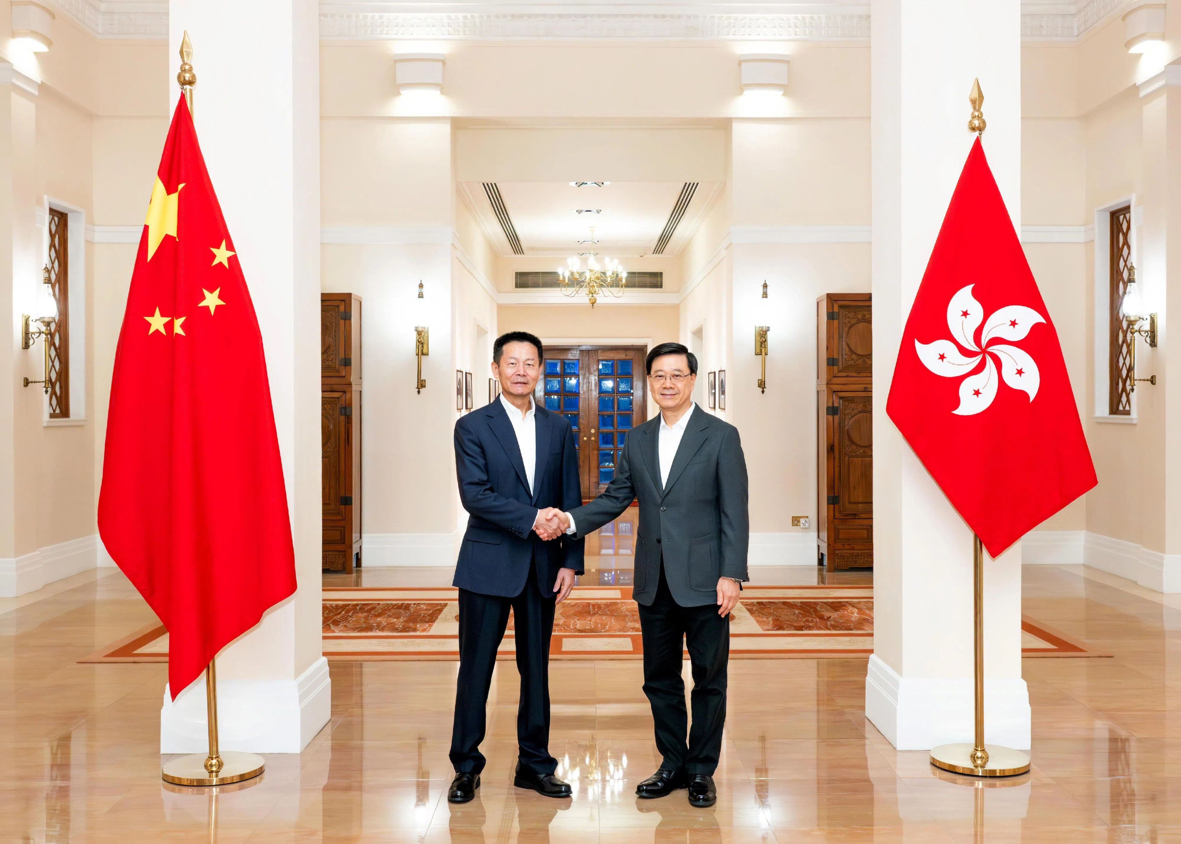 香港特首李家超（右）星期天与到访的中国证监会主席吴清会面，就深化香港与大陆金融市场互联互通交流意见。（香港政府公报官网）