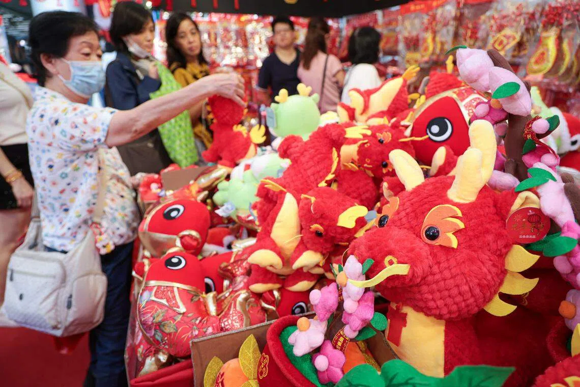 牛车水年货市场有商家抓住龙年商机，售卖造型可爱的玩具小龙，引来公众纷纷驻足。（李冠卫摄）