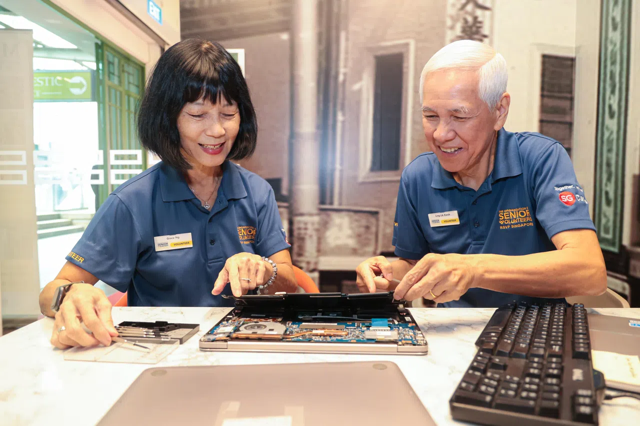 15年前不会使用电脑的黄丽玉，自从加入新加坡乐龄义工组织，开始边学习边教导他人，如今堪称“科技达人”，能够帮年长者维修电脑。图为黄丽玉向同为义工的林立国示范如何拆开电脑和查看电脑硬盘。（李冠卫摄）