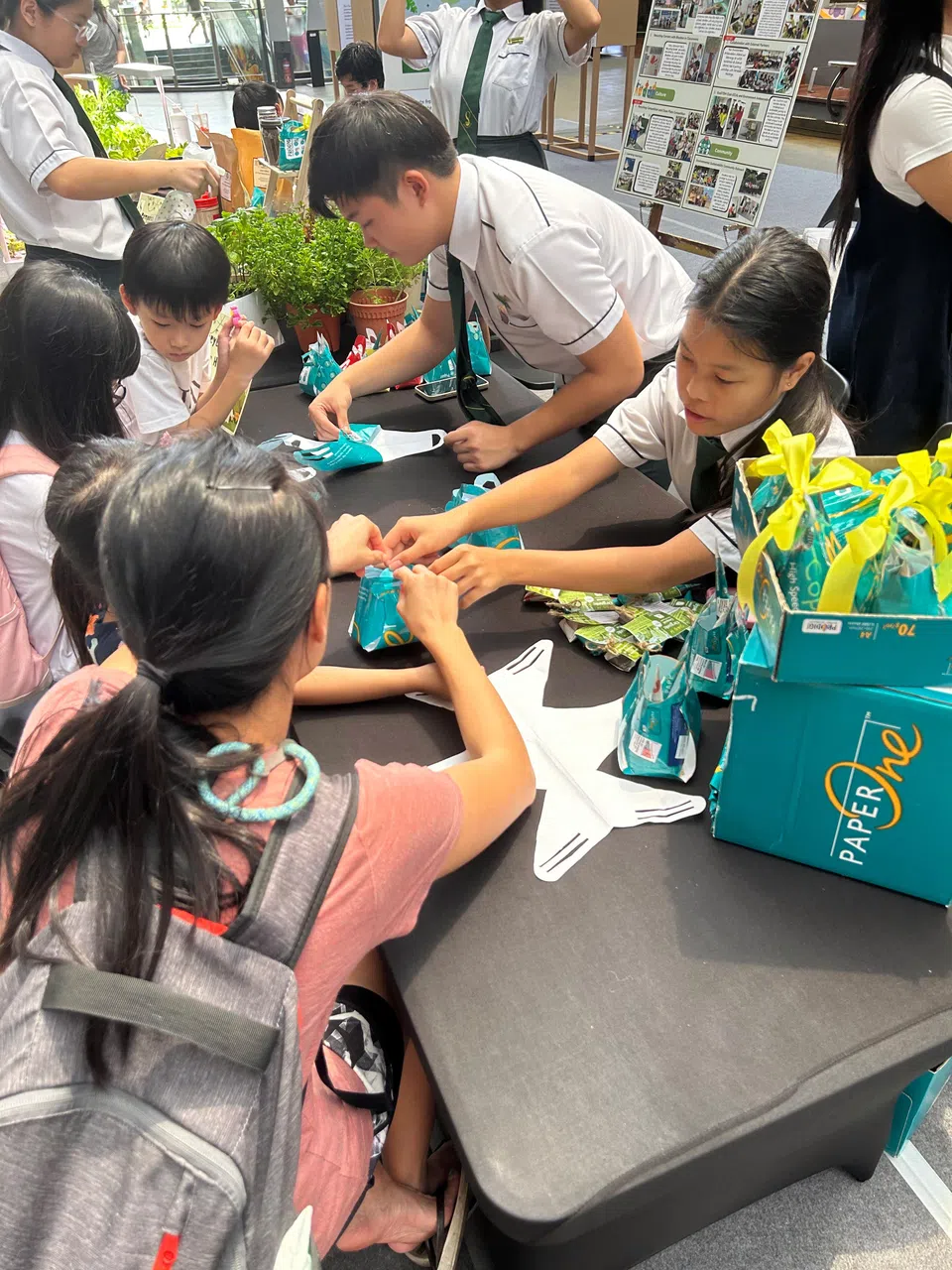 泉原中学学生在展览当天也废物利用，用纸张包装纸改制成“环保礼袋”，与居民分享他们自制的堆肥及自制的防蜗牛蛋壳碎。（泉原中学提供）