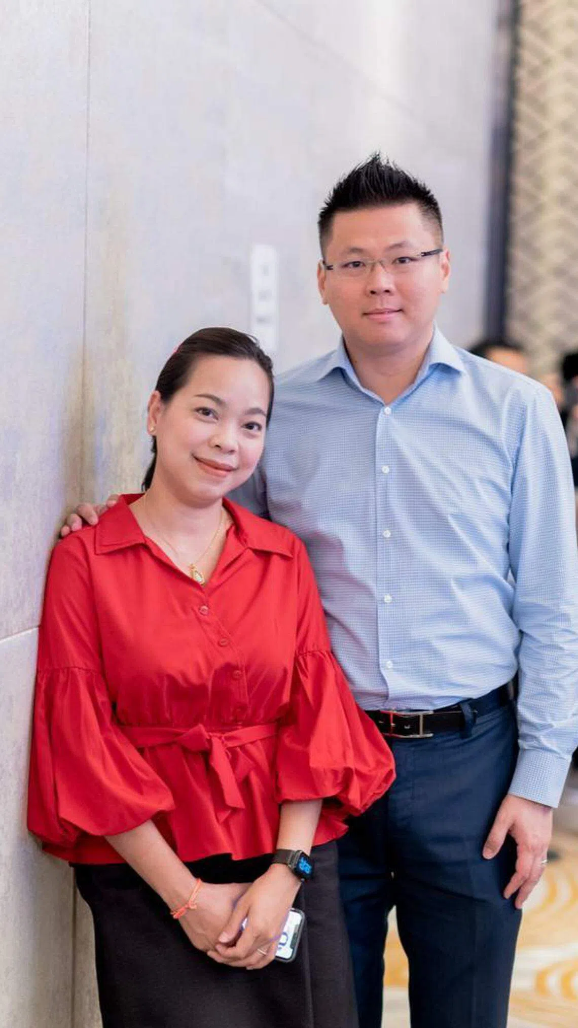 去年2月，在老挝经营教育咨询企业的李俊潭（右）与妻子宁帕苏斯在万象参加教育展会。 （受访者提供）
