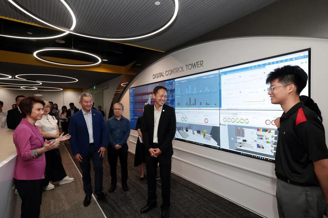 数码孪生的概念更常见于西方国家，不过我国科技发展迅速，早晚也会广泛运用。工艺教育学院率先引入，让学生们走在趋势前头。图为学生向贸工部兼文化、社区及青年部高级政务部长刘燕玲（左一）、工艺教育局总裁林国伟（左四）、工艺教育东区学院院长吴建兴（左二） 介绍“数码孪生指挥中心”。（邝启聪摄）