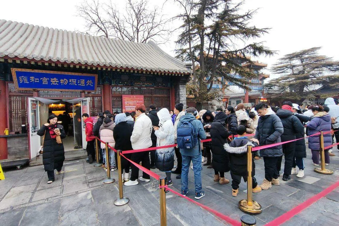 游客在雍和宫入口处的法物流通处大排长龙，只为请到心仪的雍和宫手串。（孟丹丹摄）