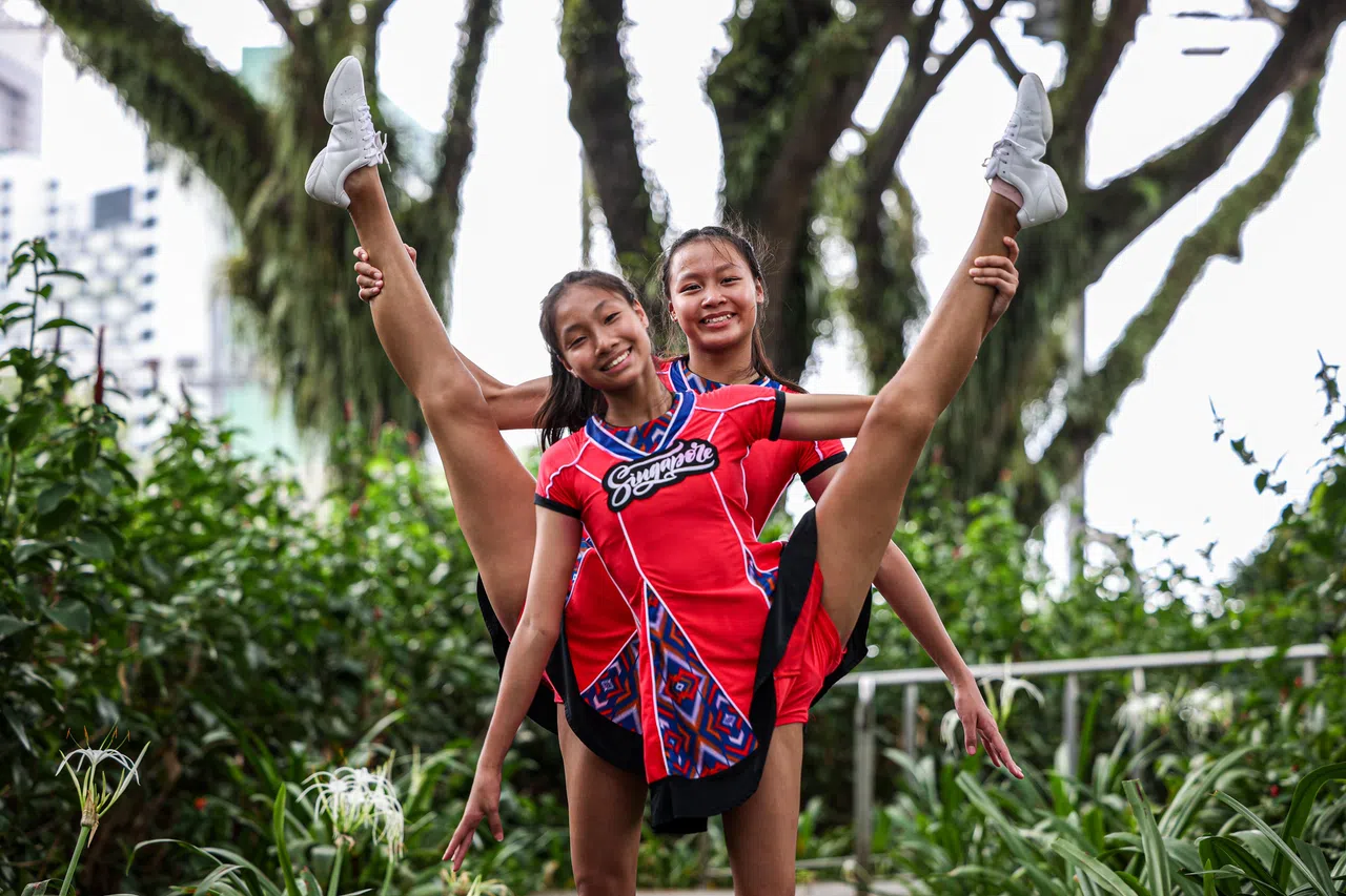 代表新加坡参赛的体操运动员周婷予（左）和姐姐周予佳首次参加庆典演出。（关俊威摄）