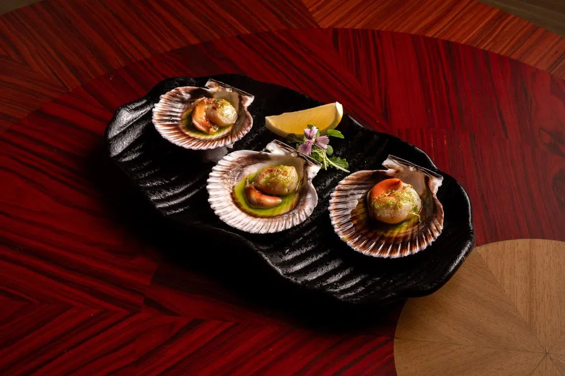 西班牙北部的带子，连壳上桌，欧芹香葱油添清新草本香气。（餐馆提供）