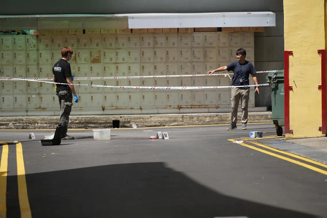 警方调查员在事发现场附近的后巷搜证，路上放置多个号码牌。（谢智扬摄）