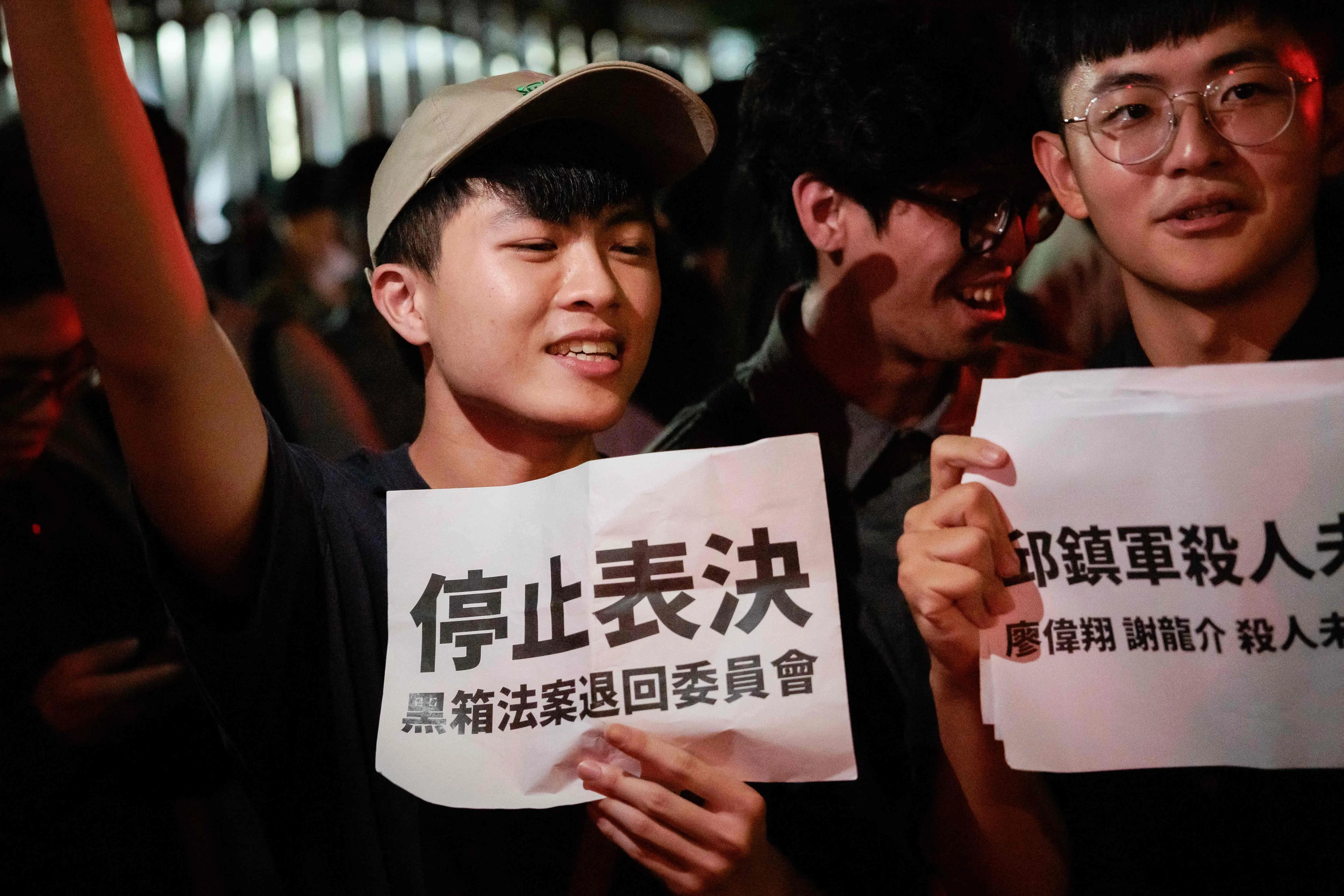 台湾蓝绿立委在立法院爆发肢体冲突后，有民众星期五晚到立法院集会，抗议立法院表决议程透明度不足，要求立法院停止表决。有民众举着标语，写道“停止表决 黑箱法案退回委员会”。（法新社）