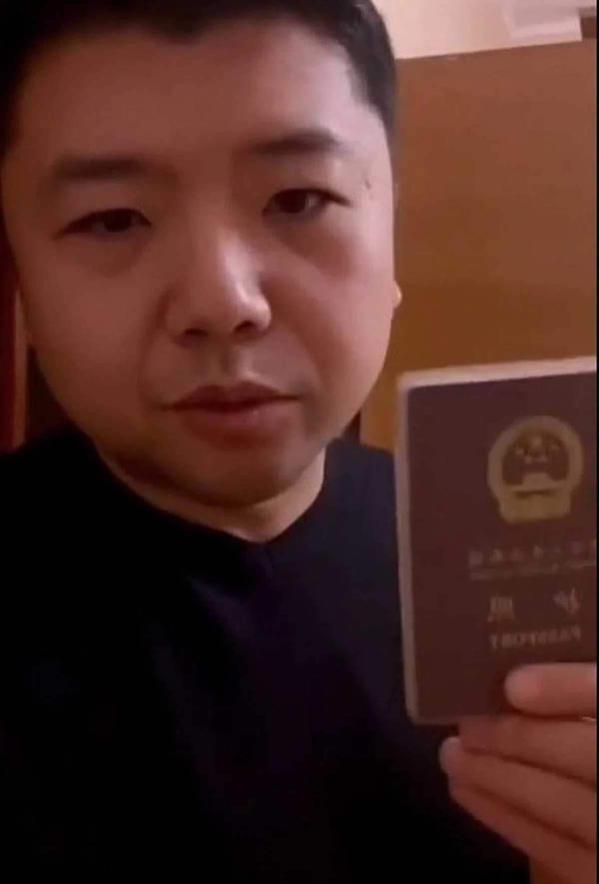一名在乌克兰的中国人展示自己的中国护照，他怒怼那些支持俄罗斯入侵乌克兰的中国网民。（视频截图）